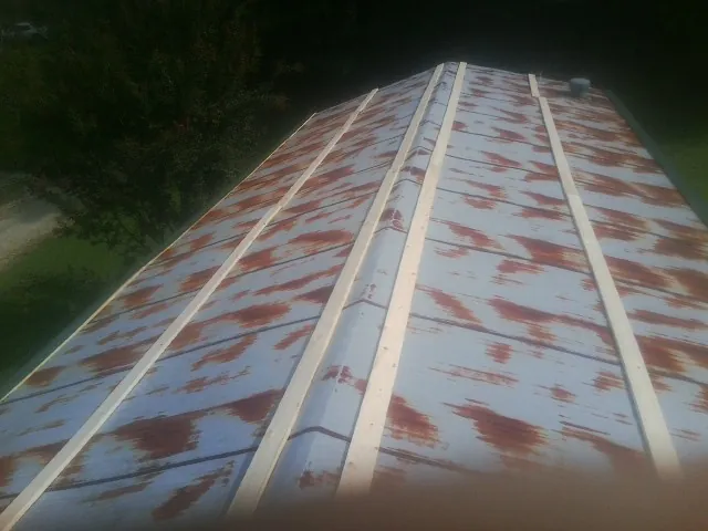 Rusted metal roof panels with new wood purlins before replacement — Storm Damage Roof Repair in Marshall by Roofing Brothers